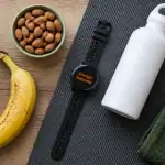 Manger une banane avant le sport sur table avec accessoires sportifs
